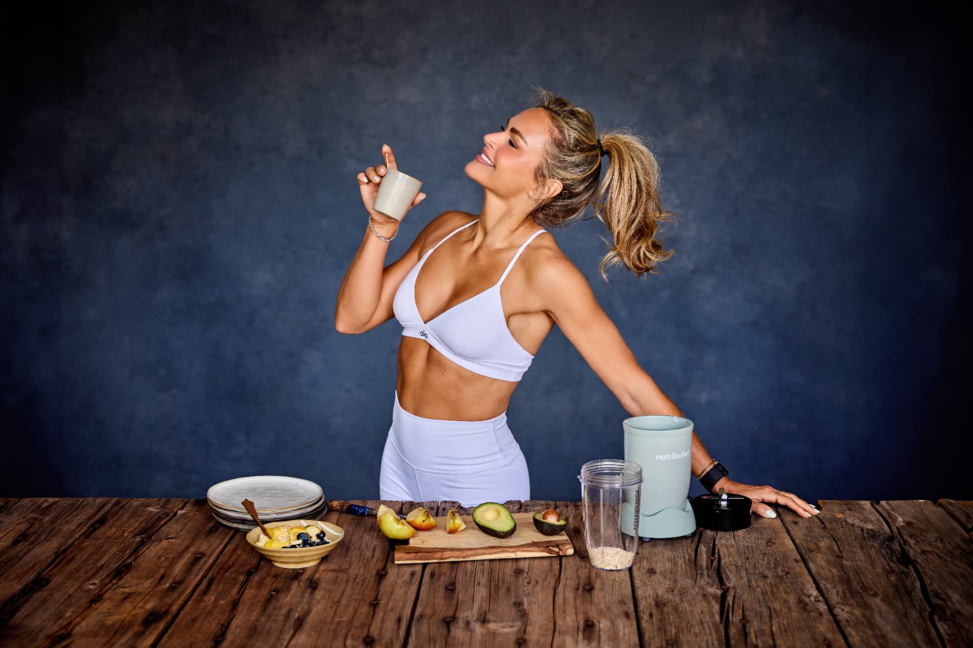 Bibi Boreel rekt zich uit aan de keukentafel met een smoothie